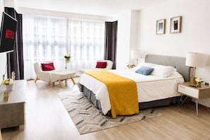 A modern hotel room with a bed, bedside table, lamp, and a television. - Horacio 1 · Steps from Antara, Polanco · 2 baths (Ciudad de México)