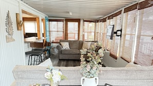 A modern living room with a sofa, a coffee table, and a dining area with chairs.