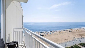 A balcony with a view of a beach with umbrellas and people. - Hilton Oceanaire Resort Escape – Oceanfront Bliss with Dual Oceanview Balconies! (Virginia Beach)