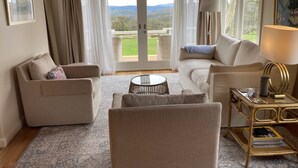 A cozy living room with a sofa, armchair, and a small round table.
