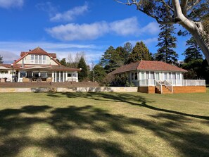 A large house with a covered patio and a smaller adjacent building with a deck.