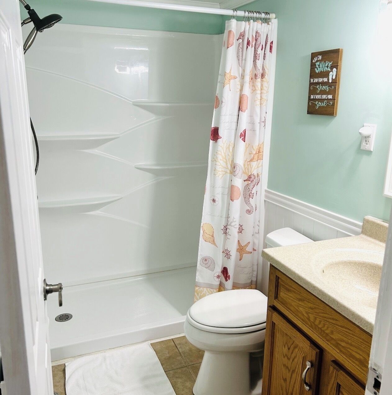 A bathroom with a shower, toilet, and vanity.