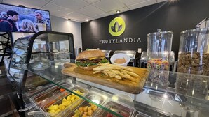 Zona de menjar a bufet amb diverses opcions, com ara sandvitxos, patates fregides i fruita.