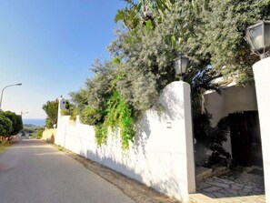 Une rue tranquille, avec des murs blancs et un lampadaire.