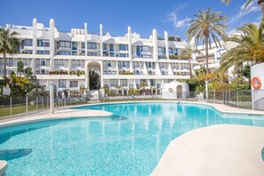 Une piscine avec un hôtel moderne en arrière-plan.