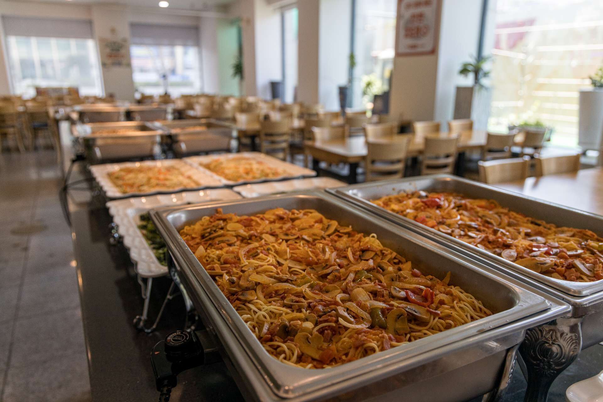 Un buffet proposant plusieurs plats de pâtes et une variété d’accompagnements.