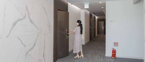 A woman entering a hotel room through a door marked with the number 501.