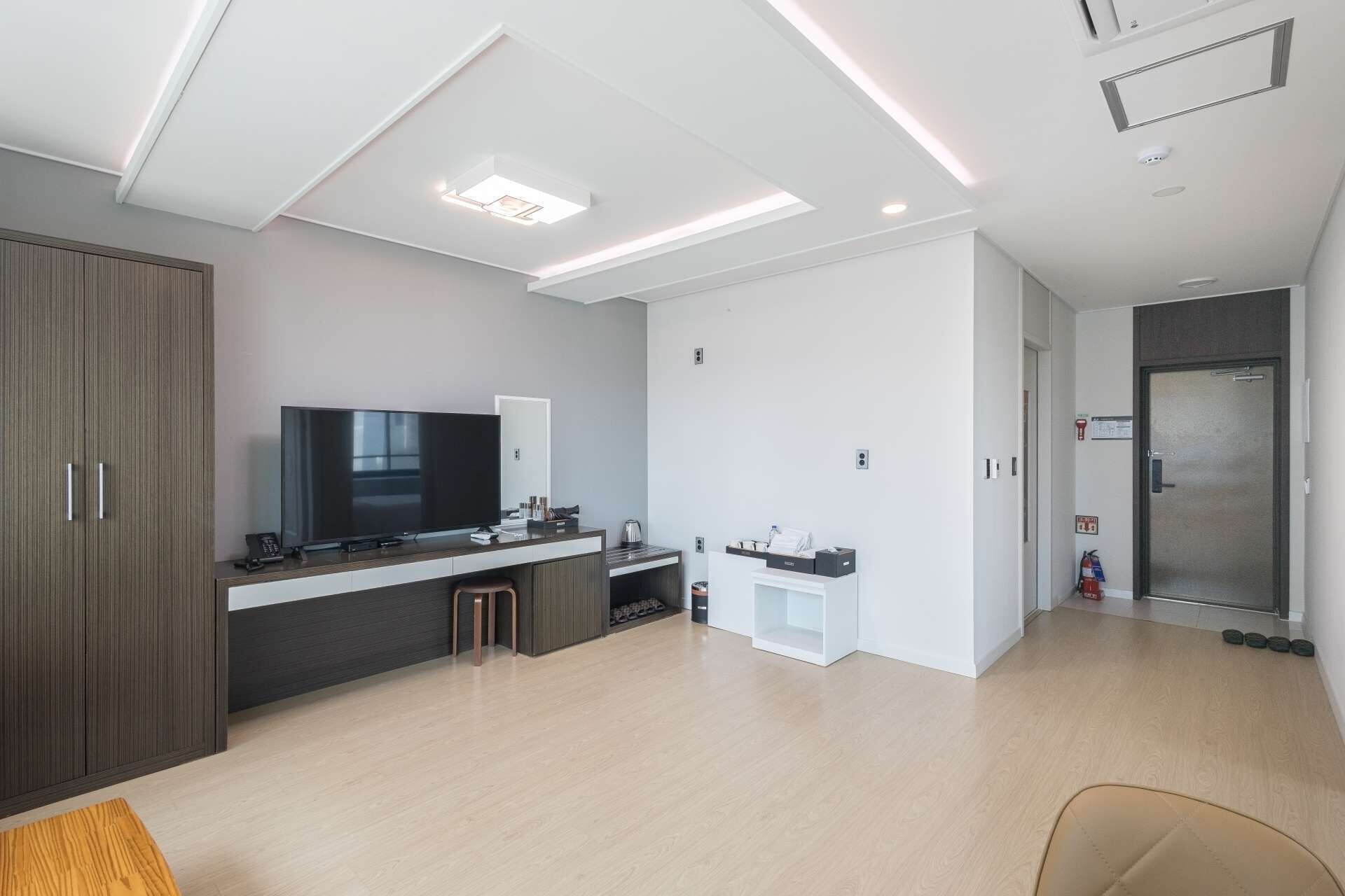 A modern kitchen with a flat-screen TV, a coffee machine, and a small bar area.