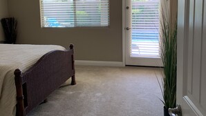A bedroom with a bed, a door, and a window. - Great family friendly home very private back yard, heated pool & covered patio. (San Tan Valley)