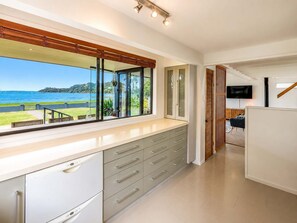 Una cucina moderna con un'ampia finestra che si affaccia su un panorama suggestivo, mobili a incasso e una TV a schermo piatto montata a parete.