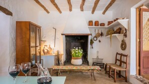 A rustic interior with a fireplace, wooden furniture, and a table with wine glasses.