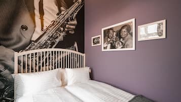 Una camera da letto con un letto, una testiera e una parete decorata con quadri.