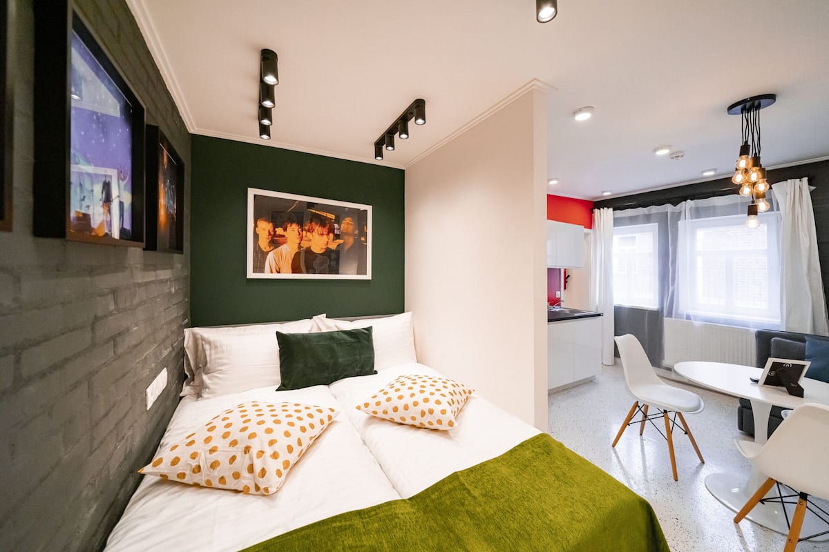 Una habitación de hotel moderna con una cama grande, un comedor y una cocina.