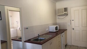 A compact kitchen with a sink, microwave, and a dishwasher. - Outback Quarters Motel Hay and Restaurant (Hay South)