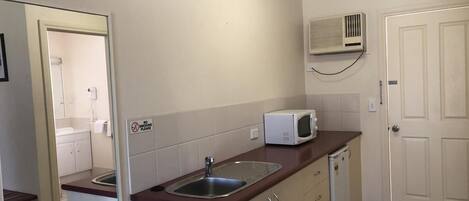 A compact kitchen with a sink, microwave, and a dishwasher.
