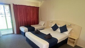 A hotel room with two beds, a small bedside table, a large window with red curtains, and a carpeted floor. - Outback Quarters Motel Hay and Restaurant (Hay South)