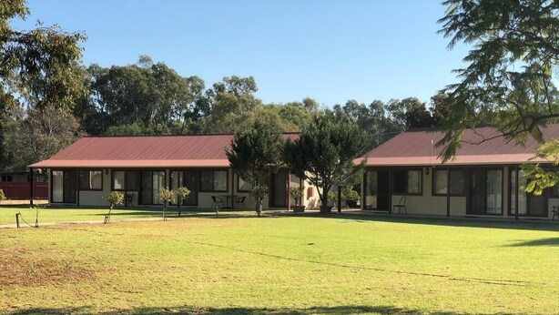 A two-story building with a red roof and a grassy courtyard. - Outback Quarters Motel Hay and Restaurant (Hay South)