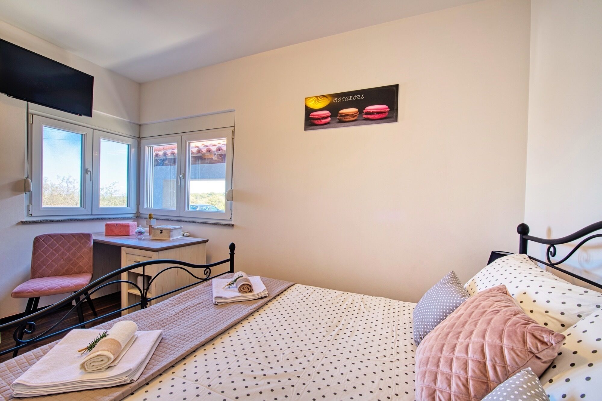 A bedroom with a bed, a desk, a chair, and a window.