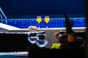 Un coin bar avec deux verres de jus d’orange et une assiette de macarons.