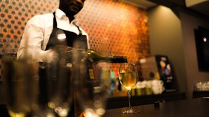 Un bar con un bartender sirviendo una bebida en un vaso.