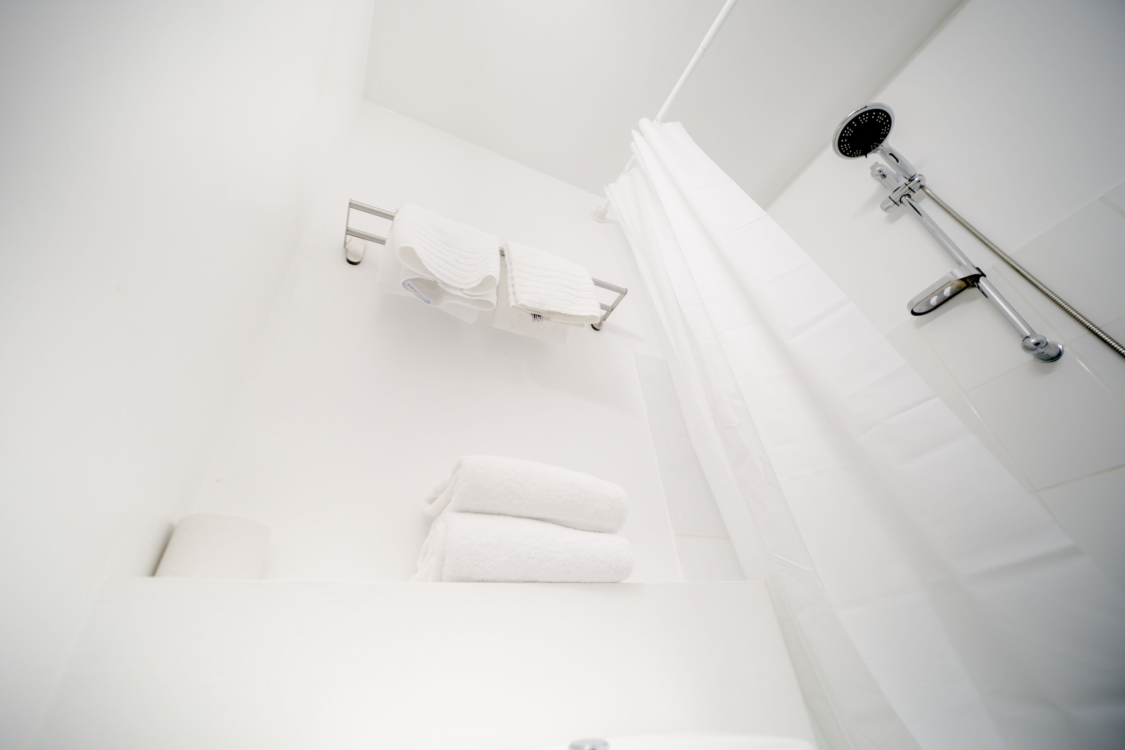 Ein modernes Badezimmer mit Dusche, Handtuchhalter und Toilette.