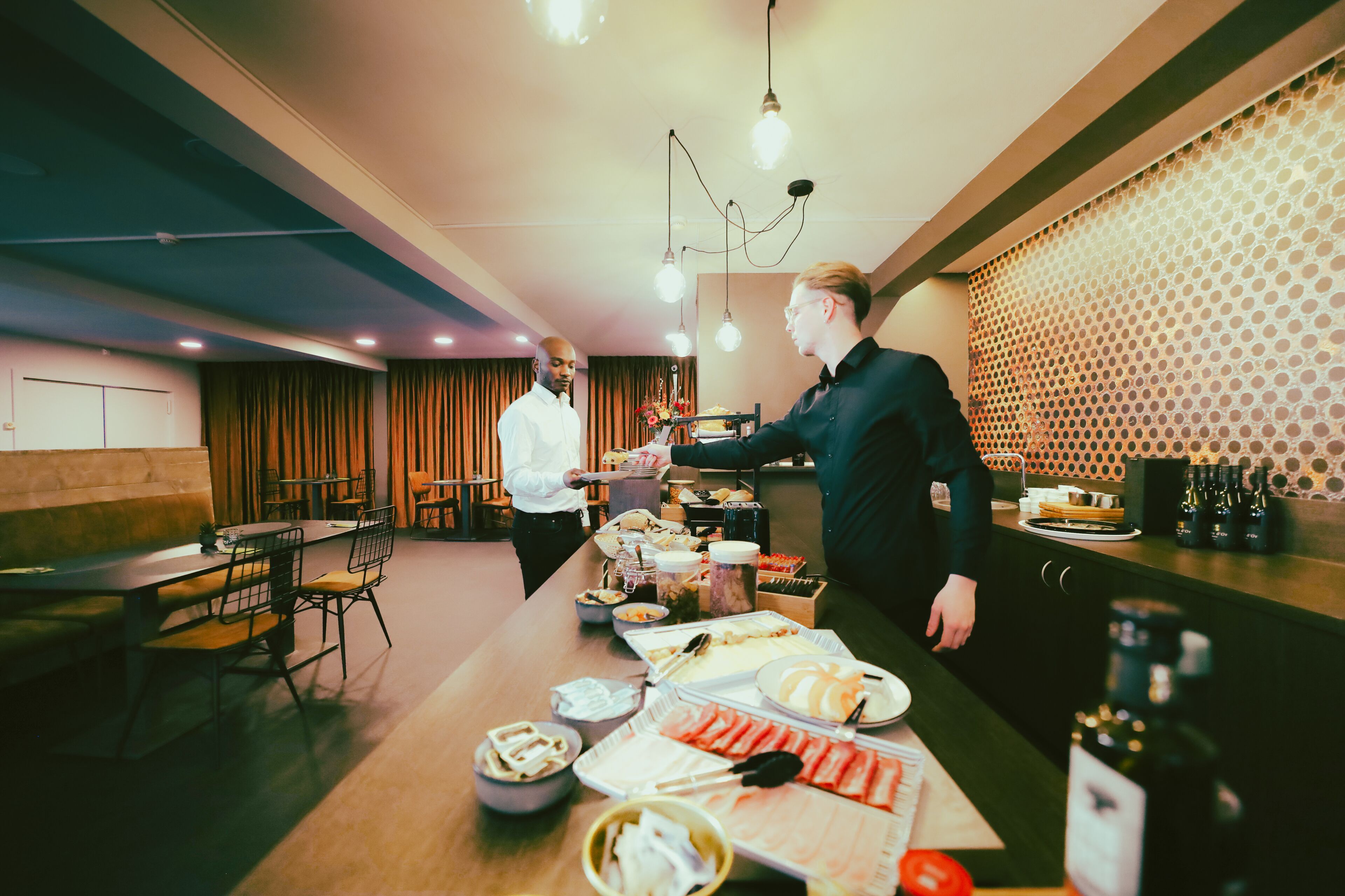 A buffet setup with various food items and a wine bottle on the counter.