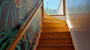 A wooden staircase with a view of the outdoors through a window at the top.