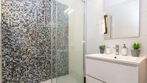 A modern bathroom with a glass shower enclosure, a white sink, and a mirror above it. - Exclusive Pool Escape Near Sea (Krk)