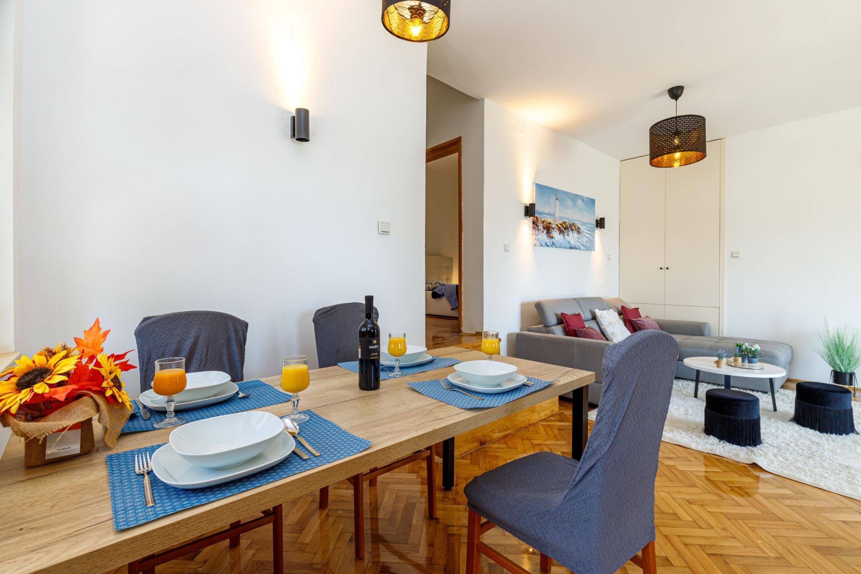Un comedor con una mesa de madera, sillas y un cuadro en la pared.