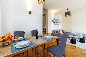 Un comedor con una mesa de madera, sillas y un cuadro en la pared.