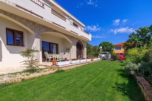 A modern two-story house with a well-maintained lawn and outdoor seating area. - Exclusive Pool Escape Near Sea (Krk)