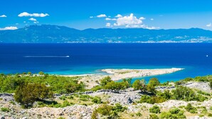 A coastal landscape with a clear view of the sea, rocky terrain, and distant mountains. - Exclusive Pool Escape Near Sea (Krk)