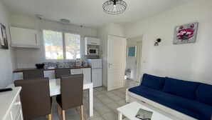 A compact living space with a kitchenette, dining area, and a blue sofa.