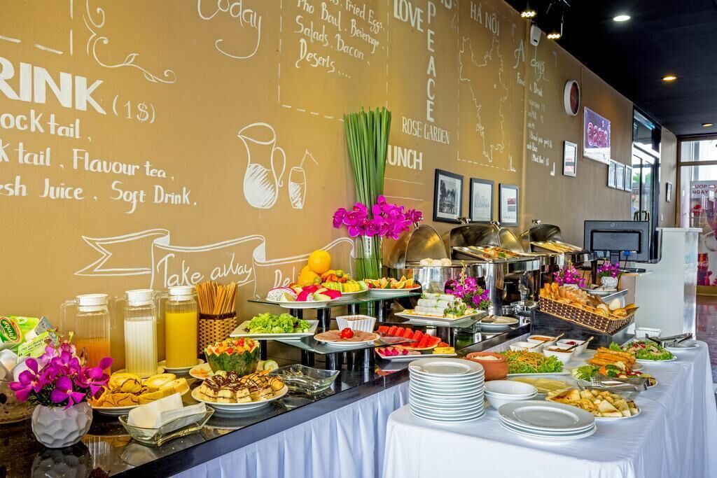A buffet setup with various food items and a drink station, including juices and soft drinks.