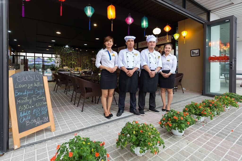 A restaurant with a chalkboard menu outside, outdoor seating, and colorful hanging lanterns.