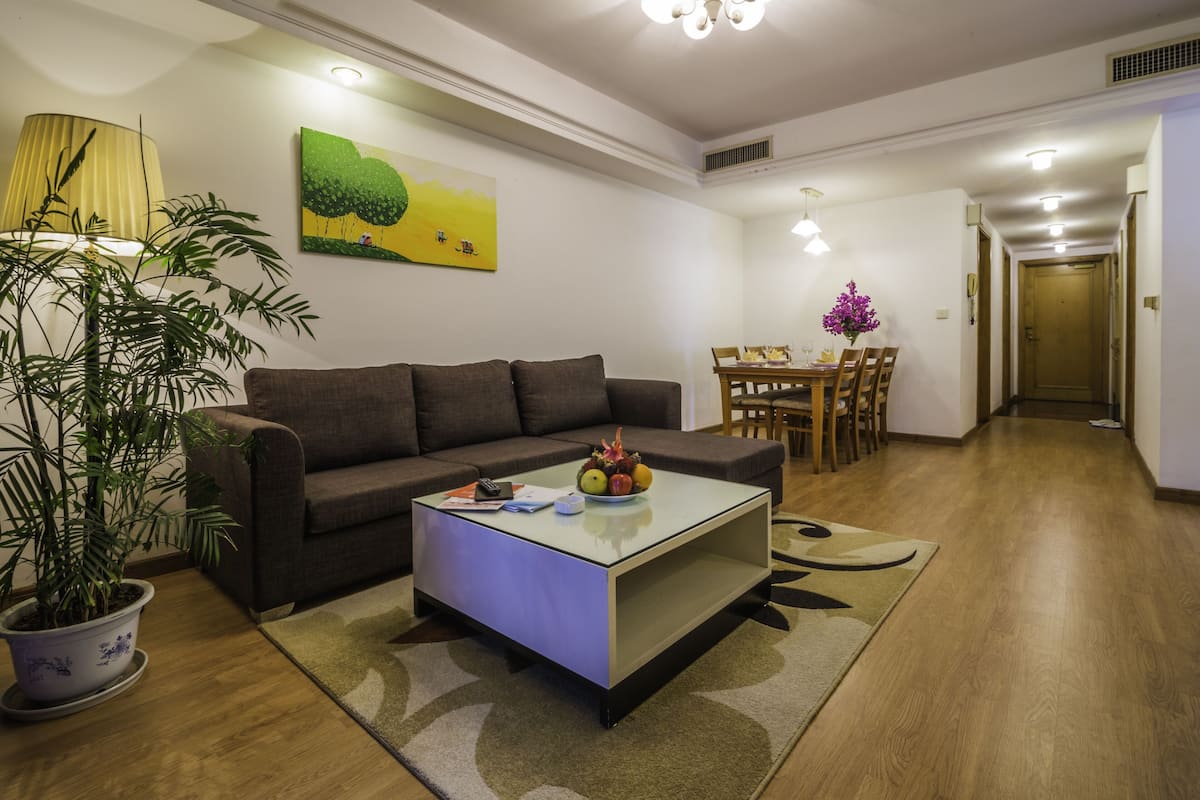 Ein Wohnzimmer mit einer Couch, einem Couchtisch und einem Essbereich mit Stühlen und einem Tisch.