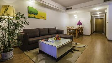 Una sala de estar con sofá, una mesa de centro y una zona de comedor con sillas y mesa.