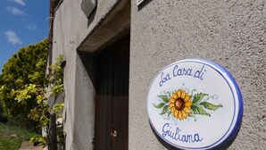 Un letrero con un girasol y el texto "La Casa di Giuliana" en una pared de edificio.