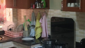 Cozinha com armários de madeira, fogão a gás e diversos utensílios.