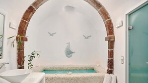A bathroom with a white bathtub, a white sink, and a white towel rack.