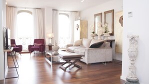 Ein geräumiges Wohnzimmer mit einer Couch, Sesseln und einem Couchtisch.