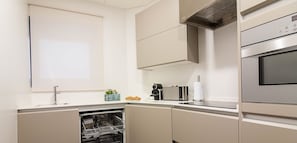 A modern kitchen with a dishwasher, a coffee maker, and a built-in oven.