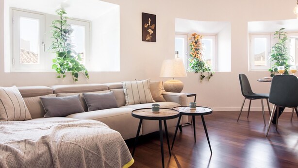 A modern living room with a sofa, two small tables, a chair, and potted plants. - Malaga Luxury City Center. Parking (Málaga)