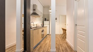 Eine moderne Küche mit Holzausstattung, einer Mikrowelle und einem eingebauten Backofen.