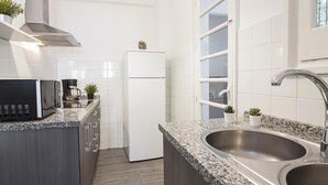 Una cocina moderna con encimeras de granito, electrodomésticos de acero inoxidable y un lavamanos doble.