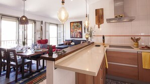 Cozinha moderna com ilha central, armários de madeira e iluminação pendente.