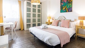 A hotel room with a bed, bedside tables, a desk, a chair, a wardrobe, and a painting on the wall. - Malaga Exclusive Beach Apartment with Terrace (Málaga)