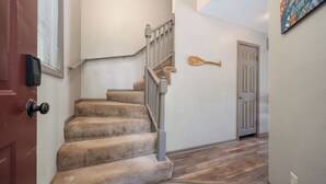 Eine Teppichstufen-Treppe mit einer Holztür und einem Schläger an der Wand.
