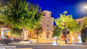 A public square with steps leading up to a building with a clock tower, surrounded by trees and outdoor seating. - Studio Paula 5 300m From Sea (Crikvenica)
