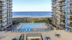 A hotel with a pool, lounge chairs, and a view of the ocean. - 2 Bedroom, 2 Bath Side Unit with fantastic views of the ocean and pool (Ocean City)